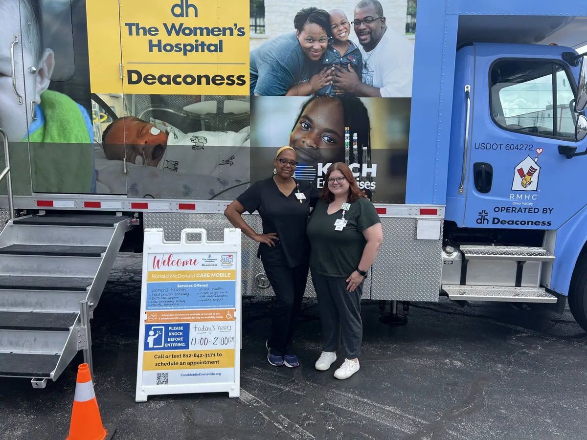 Two staff members beside the Ronald McDonald Care Mobile.