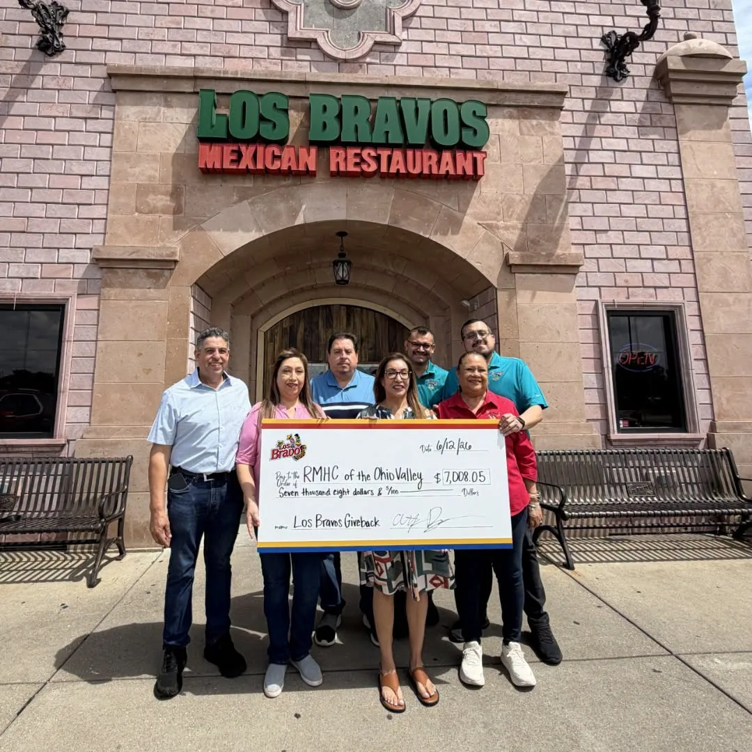 Los Bravos Mexican Restaurant team presenting a give-back check outside the restaurant.