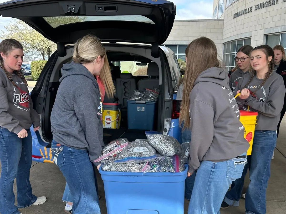 Volunteers delivering containers of collected pop tabs.