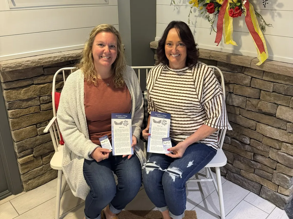 Two volunteers holding family care kits they assembled.