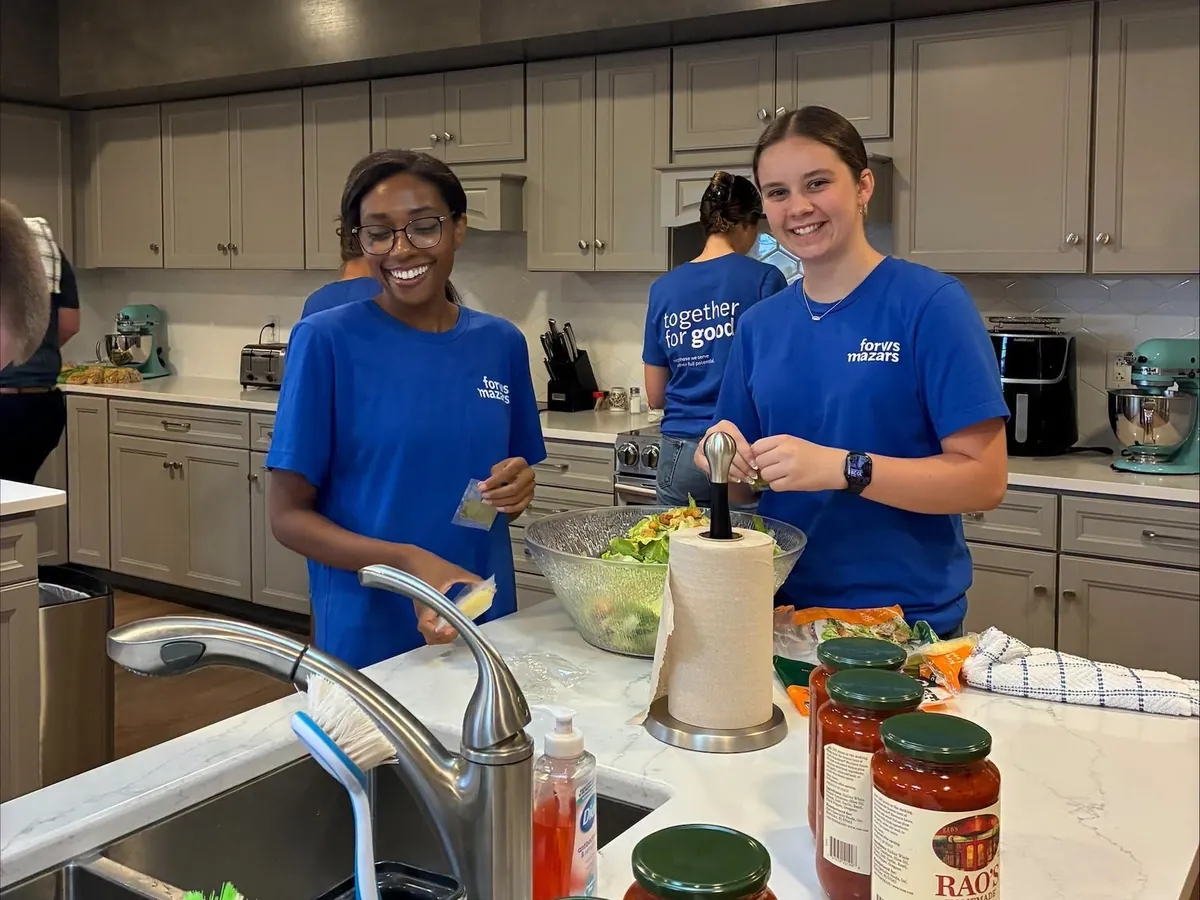 Forvis volunteers preparing a meal in the House kitchen.