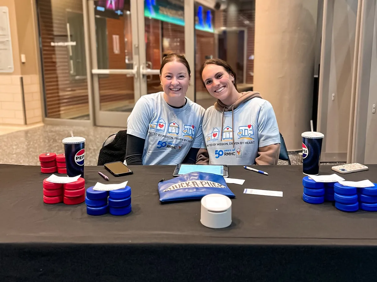 Two volunteers sharing information at an outreach table.