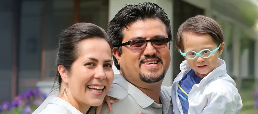 A smiling mother and father with their young son.