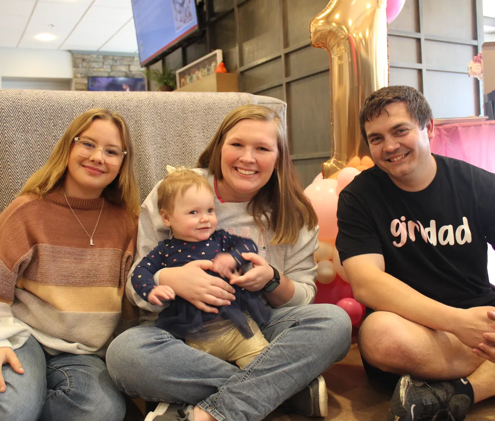 Family sitting together with a young child.