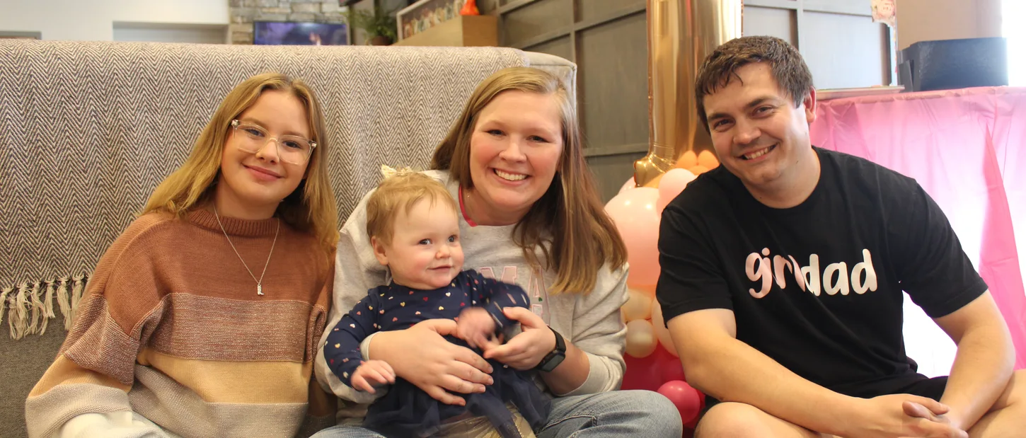 Family sitting together with a young child.