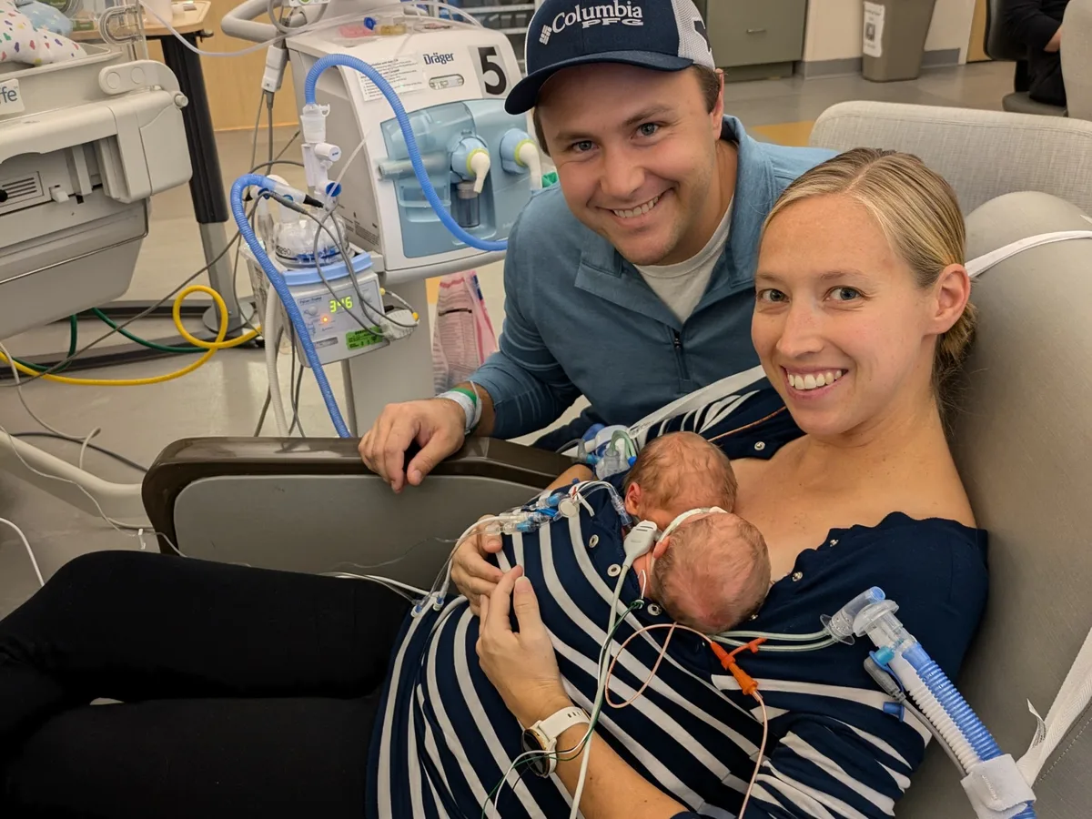 Parents with their infant in a hospital room.
