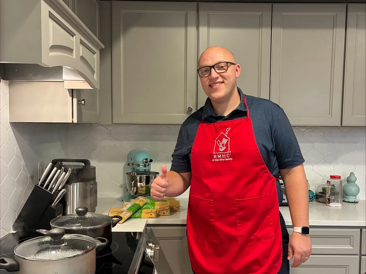 Volunteer preparing a meal in a Ronald McDonald House kitchen.