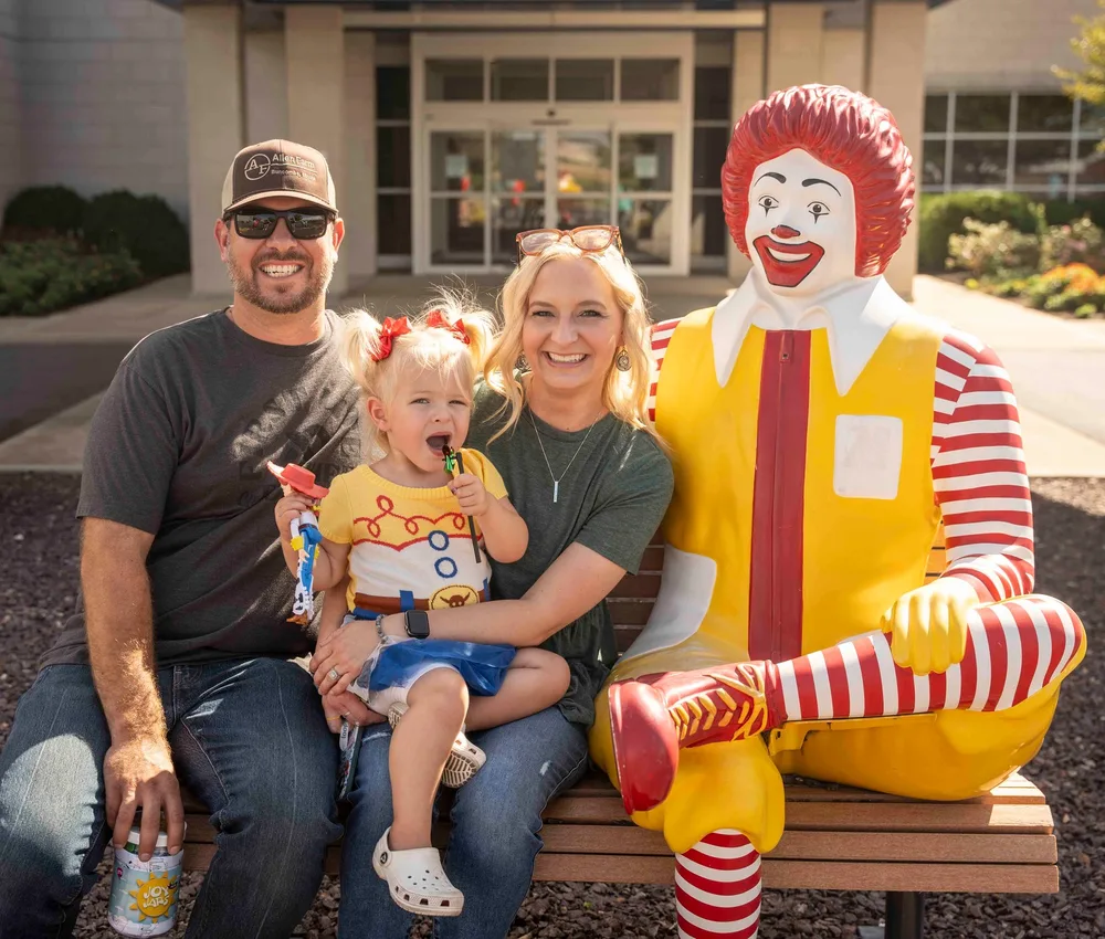 Family with Ronald McDonald outside Ronald McDonald House.