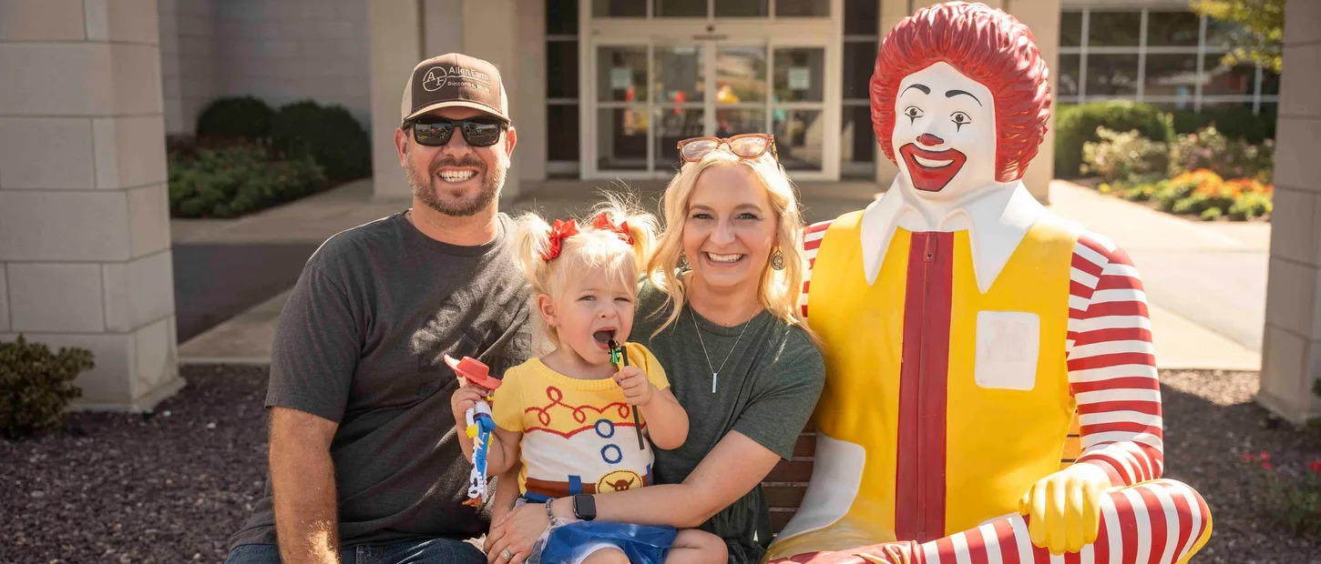 Family with Ronald McDonald outside Ronald McDonald House.