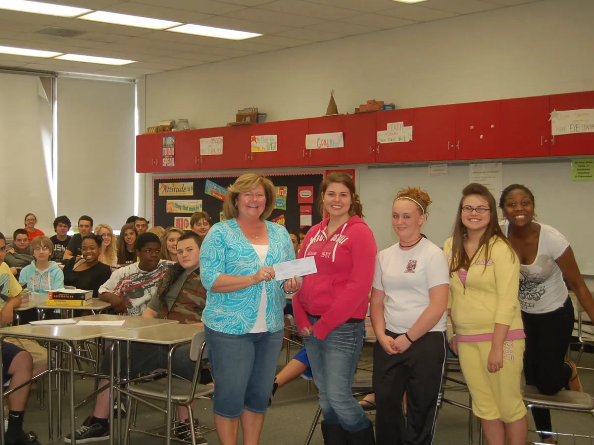 Students presenting a fundraiser donation in their classroom.