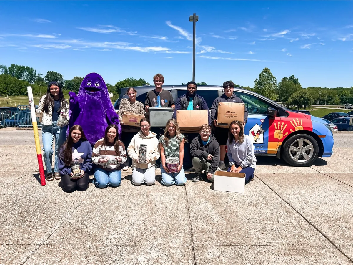 Students with Grimace and boxes of collected pop tabs.