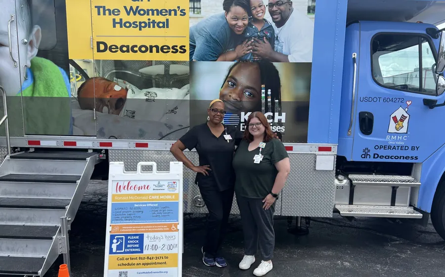 Two Care Mobile team members beside the Ronald McDonald Care Mobile.